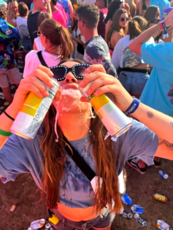 A partygoer holding cans in the crowd